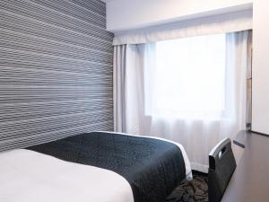 a bedroom with a bed and a window at APA Hotel Akihabara Ekimae in Tokyo