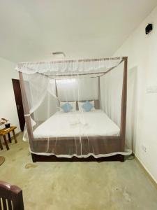 una cama con dosel en una habitación en Lagoon Home Stay, en Ahangama