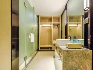 a bathroom with a sink and a mirror at Yishang Hotel Anshun High-speed Railway Station Airport Road Branch in Anshun
