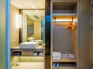 a bathroom with a sink and a mirror at Yishang Hotel Anshun High-speed Railway Station Airport Road Branch in Anshun