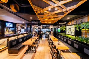 a restaurant with wooden tables and benches at The All New Stark Boutique Hotel in Kuta