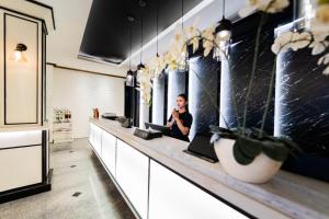 a man sitting at a counter in a bathroom at The All New Stark Boutique Hotel in Kuta +20 photos