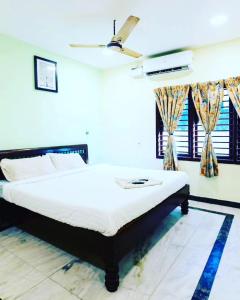 una camera da letto con un letto e un ventilatore a soffitto di Le Haayt Resort With pool a Pondicherry