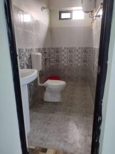 a bathroom with a toilet and a sink at Namsay Hotel in Bomdila +4 photos