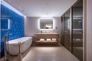 Orange Crystal Qingdao Taidong Pedestrian Street Yan'an Third Road Hotel في تشينغداو: حمام مع حوض استحمام ومغسلة ومرآة +28 صورة