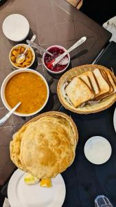 einen Tisch mit Kuchen und Schüsseln aus Essen in der Unterkunft Boho Regency in Shimla