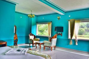 耶拉吉里Hill Fort Hotel And Resorts Yelagiri Hills的一间有蓝色墙壁、蓝色椅子和一张床的卧室