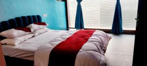 Un dormitorio con una cama con una manta roja y blanca. en Hotel O TOYBOX, en Dānāpur