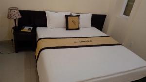 a bed in a hotel room with a pillow on it at Bideco Hotel in Thu Dau Mot
