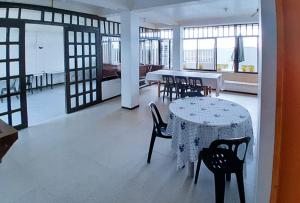 a dining room with a table and chairs and windows at Balay Baybay Roxas in Roxas City