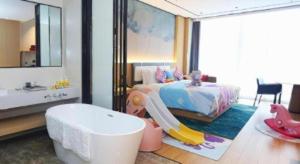 una camera da letto con un letto e una vasca e un bagno per bambini di Ramada Encore by Wyndham Jinan Shanghe a Shang-ho-hsien Altre 65 foto