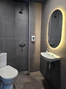 a bathroom with a toilet and a sink and a mirror at Tai Hoe Hotel in Singapore