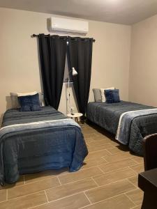 a bedroom with two beds and a window with curtains at LiV109 Norte Depa 8 Cd Obregon in Ciudad Obregón