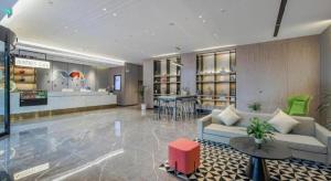 eine Lobby mit einem Sofa und einer Bar in einem Geschäft in der Unterkunft Borrman Hotel Nanning Wuming Center in Wuming