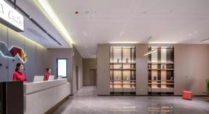 Eine Frau, die an einem Tresen in einer Lobby steht. in der Unterkunft Borrman Hotel Nanning Wuming Center in Wuming