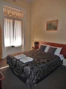 Un dormitorio con una cama grande y una ventana en Great Central Hotel, en Glen Innes