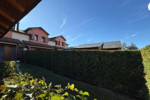 una valla de setos delante de unas casas en La caseta dels jardins, en Osséja