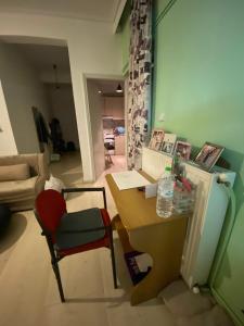 Zimmer mit einem Schreibtisch, einem Tisch und einem Kühlschrank. in der Unterkunft Sroom in Kardítsa