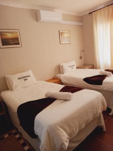 a hotel room with two beds and a window at Punyu International Hotel in Khomas Region