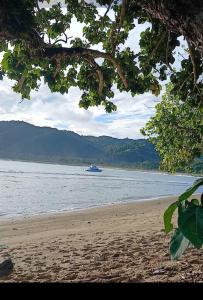 um barco está na água em uma praia em SeaSide HomeStay and Airport Shuttles em Korotogo