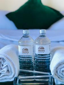 two bottles of water sitting on a table with towels at Mita Hotel in Dhulikhel