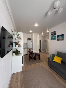 a living room with a couch and a table at Апартаменты в Чайка Резорт, Иссык-Куль in Chon-Sary-Oy