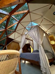 Un dormitorio con una cama con dosel en una tienda de campaña. en Axtra Glamping, en Tapalpa 25 fotos más