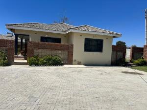 ein Haus mit einem Ziegelzaun und einer Ziegelauffahrt in der Unterkunft Hatfield staylax Manor 1 in Harare