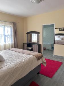 Un dormitorio con una cama grande y un espejo. en Hatfield staylax Manor 1, en Harare