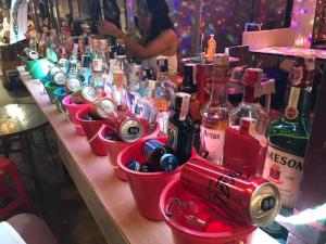 a row of bottles of alcohol in buckets on a table at JAM's HOSTEL in Ko Phangan