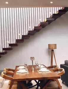 a wooden table with wine glasses and a staircase at Villa Jasmine in Seminyak +11 photos