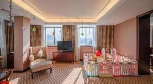 南宁Nanning Yongjiang Hotel的客厅，带儿童房，配有婴儿床