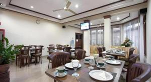 a restaurant with tables and chairs and a television at Hotel Griyadi Kusuma Sahid in Solo +24 photos