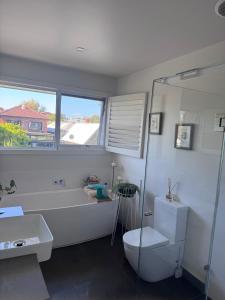 a bathroom with a tub and a toilet and a sink at Inner city quiet cottage in Melbourne