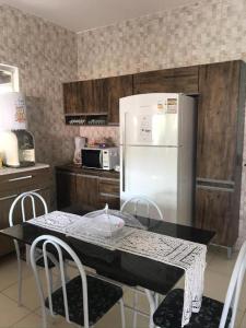 塞古罗港Casa Vista Atlântica的厨房里有一张桌子和一台白色冰箱