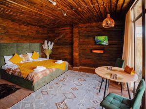 a bedroom with a bed and a table in it at Pik Talgar Eco Village in Talghar