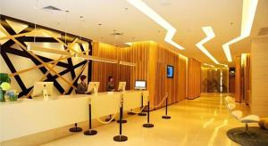 a lobby with two people sitting at a desk at Echeng Hotel Qinzhou Bay Plaza East High-speed Railway Station in Qinzhou