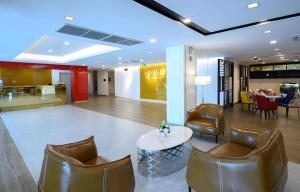 a lobby with leather chairs and a table and a restaurant at IWISH Hotel Bangkok in Ban Bang Khen (1)