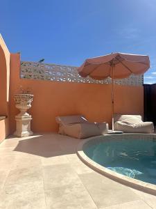 a patio with an umbrella and a swimming pool at Pacific Sun Bargara in Bargara