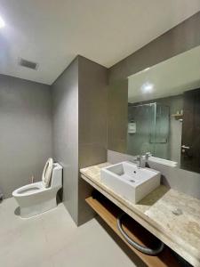 Apartemen Patraland Amarta Yogyakarta في Kejayan: حمام مع حوض ومرحاض