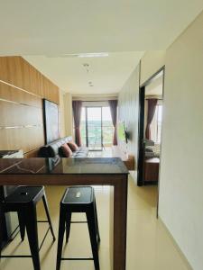 Apartemen Patraland Amarta Yogyakarta في Kejayan: غرفة مع سرير ومكتب مع كرسيين