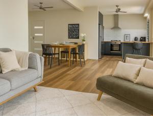 塔勒布吉拉Tallebudgera Hinterland Retreat的客厅里有一张沙发、一张桌子和几把椅子 更多8张照片