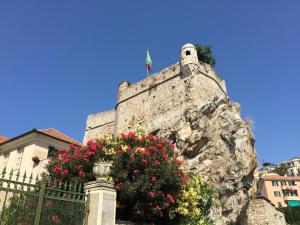 kamienna ściana z kwiatami przed budynkiem w obiekcie Al Castello Affittacamere w mieście Pietra Ligure