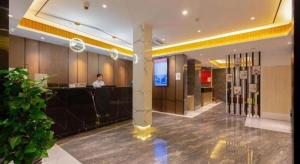 a woman standing at a counter in a hotel lobby at Gya Hotel Shanghai Long Distance Passenger Terminal Station in Shanghai