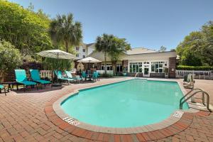 ein Swimmingpool mit Stühlen und ein Haus in der Unterkunft Homewood Suites by Hilton Charleston - Mount Pleasant in Charleston