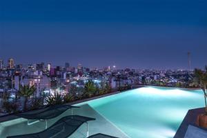 uma piscina com vista para a cidade à noite em Andaz Condesa Mexico City, By Hyatt em Cidade do México