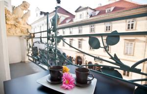 a table with two cups and flowers on a balcony at Charles IV Apartments in Prague