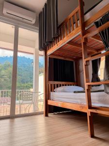a bedroom with two bunk beds and a balcony at Little wild hostel khaosok in Khao Sok National Park
