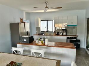 a kitchen with a counter with a microwave and a refrigerator at Hichinbrook Lodge, waterfront in Cardwell