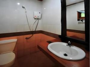 皮皮岛Phuttachot Resort的浴室里有洗手池、马桶和镜子。